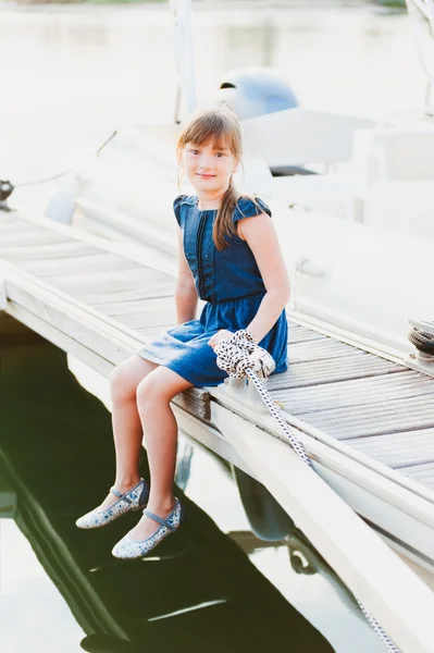 Retrato ao ar livre de uma menina bonito descansando em um porto no pôr do sol — Fotografia de Stock