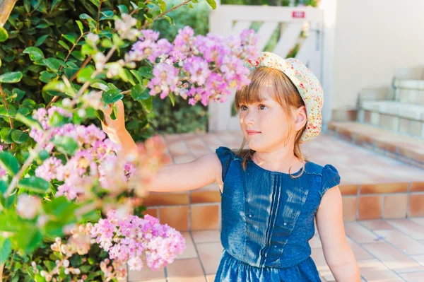 Söt liten flicka spelar med blommor på en fin solig dag, utomhus — Stockfoto