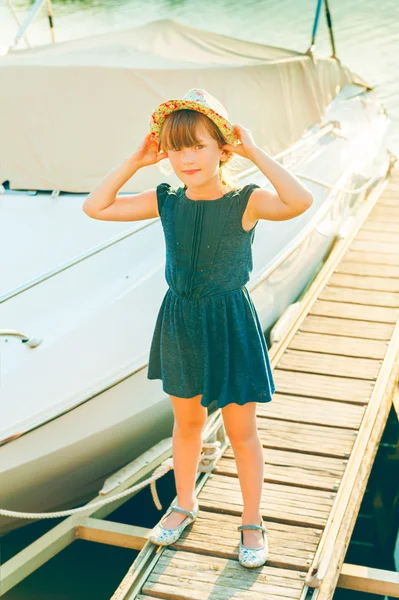 Outdoor portrait of a cute little girl resting in a port on sunset — Stock Photo, Image