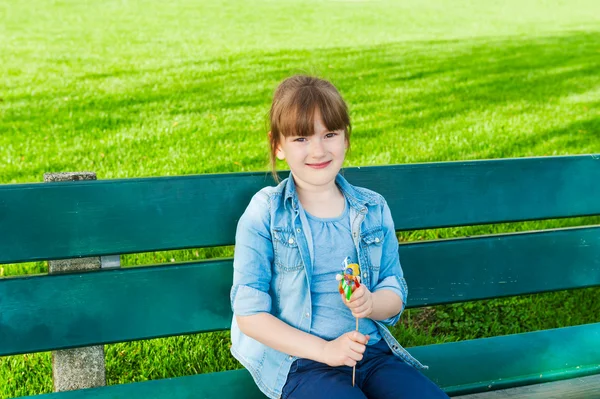 Outdoor Portret van een schattig klein meisje op een bankje — Stockfoto