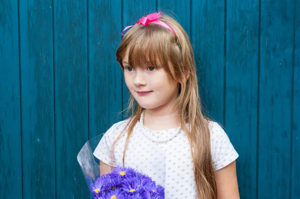 Mor çiçekler buket sevimli küçük kız — Stok fotoğraf