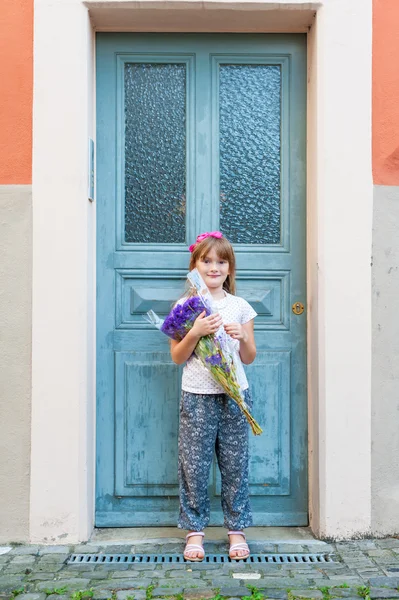 Niña adorable con ramo de flores violetas —  Fotos de Stock