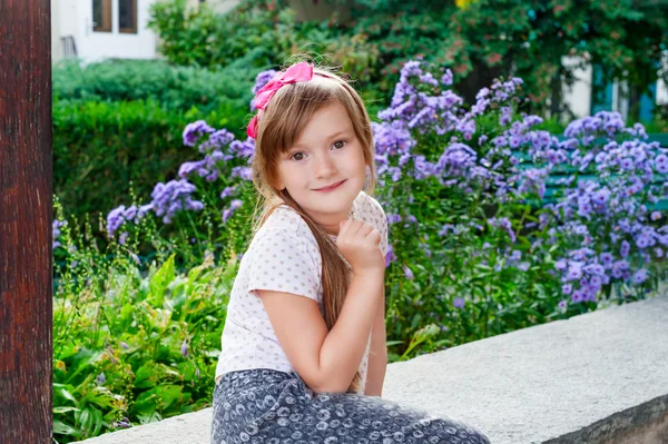 Schattig meisje met bloemen op achtergrond — Stockfoto