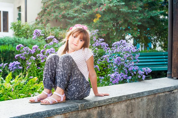 Schattig meisje met bloemen op achtergrond — Stockfoto