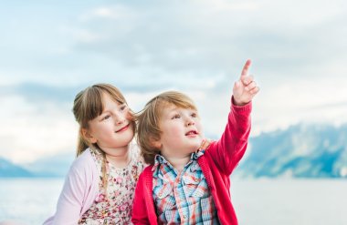 Bir şey güzel kız kardeşiyle havada gösterilen sevimli yürümeye başlayan çocuk