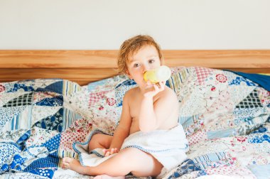 Tatlı ltoddler çocuk üzerinde kötü bir, rahatlatıcı bir plastik şişe süt içme kaplı havlu ile