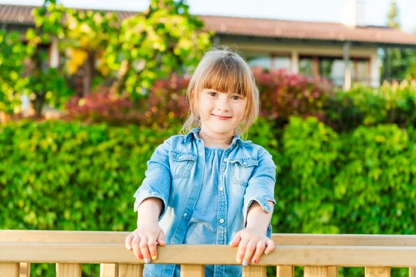 Outdoor portrait of adorable little girl on a nice sunny day, wearing a jeans shirt — Stock Photo, Image