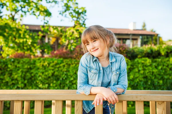 ジーンズのシャツを着て素敵な晴れた日にかわいい小さな女の子の屋外のポートレート — ストック写真