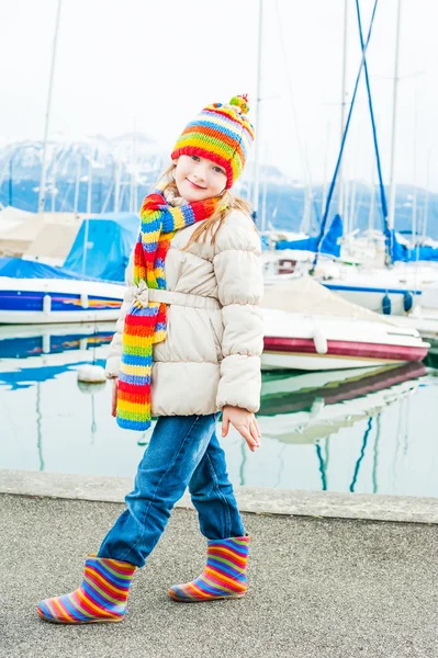 Utomhus porträtt av en söt liten flicka klädd i kavaj och färgglad mössa och halsduk — Stockfoto