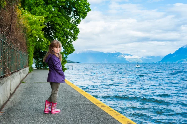 Zewnątrz portret ładny małej dziewczynki, noszenia Kurtka przeciwdeszczowa i buty — Zdjęcie stockowe