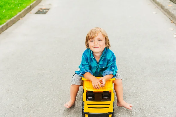 Little toddler boy playing with big toy car, outdoors — Stock Photo, Image