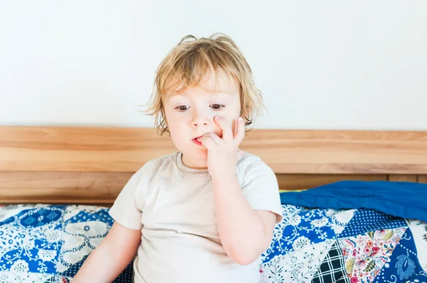 Interiör porträtt av en söt liten knatte pojke bita naglar — Stockfoto