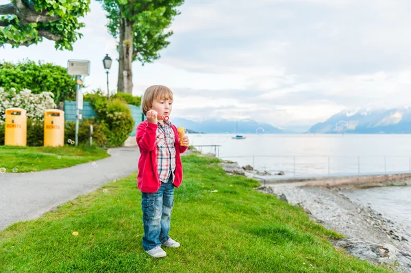 Cute toddler boy playing with soap bubbles on a nice summer evening — Stock Photo, Image