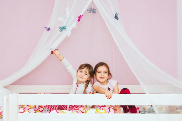 Schattige meisjes spelen samen op het bed — Stockfoto