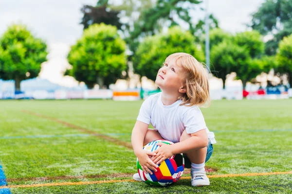 Lindo niño jugando con una pelota en un estadio —  Fotos de Stock