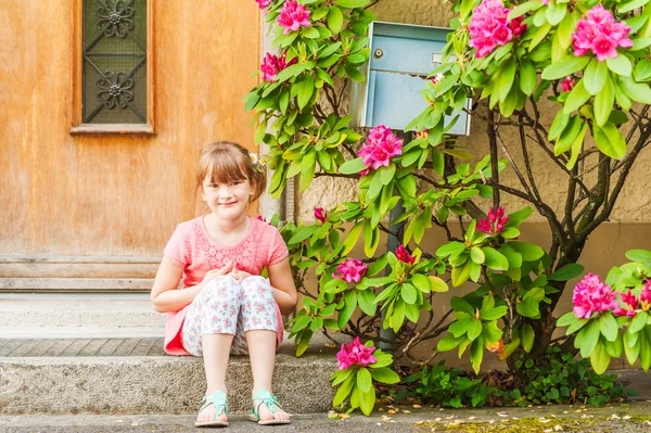 Outdoor portrait of a cute little girl on a nice sunny day, wearing coral dress and printed leggings — Stock Photo, Image