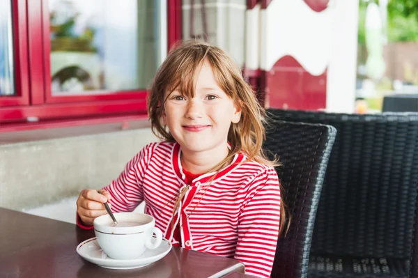 Schattig klein meisje warme chocolademelk drinken in een café — Stockfoto