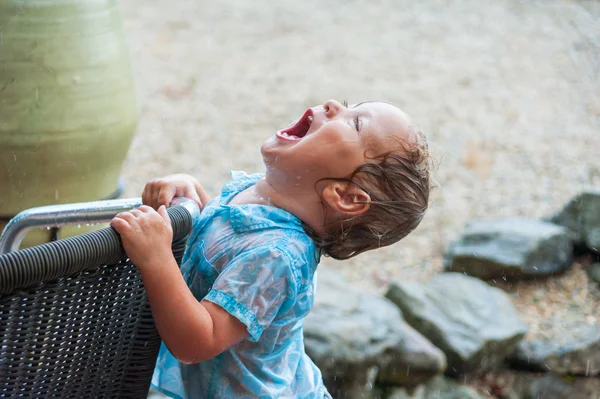 Schattige babyjongen spelen onder de regen — Stockfoto