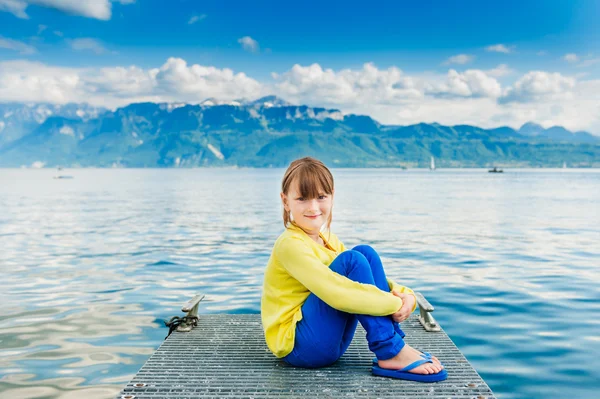 Außenporträt eines süßen kleinen Mädchens mit gelbem Oberteil und blauer Hose — Stockfoto