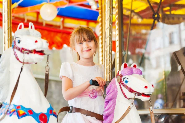 Küçük kız carousel eğleniyor