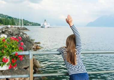 Sevimli küçük kız bir yelkenli tekne ağırlıyor