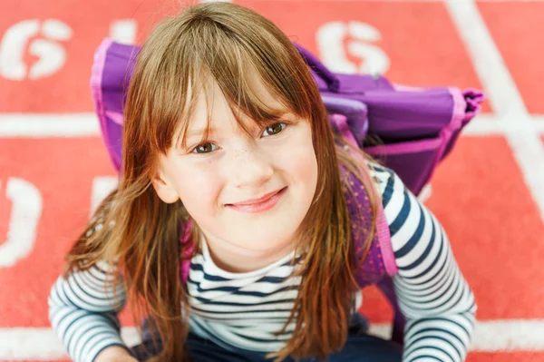 Close up retrato de uma menina bonito com mochila em um pátio da escola — Fotografia de Stock