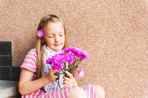 Kid flicka med rosa blommor, närbild porträtt — Stockfoto