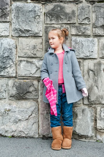 Retrato al aire libre de una linda niña con un abrigo gris, jeans y botas marrones —  Fotos de Stock