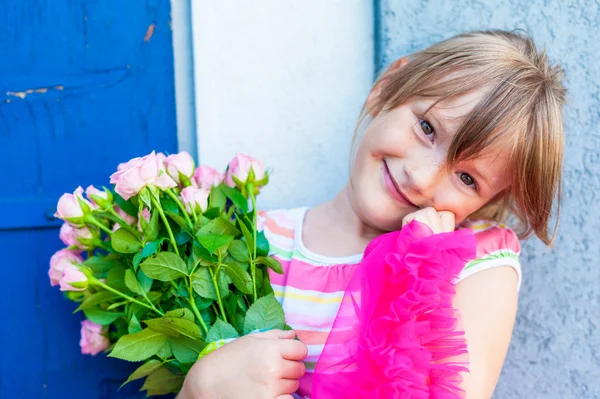 Belle petite fille aux roses roses, portrait en plein air — Photo