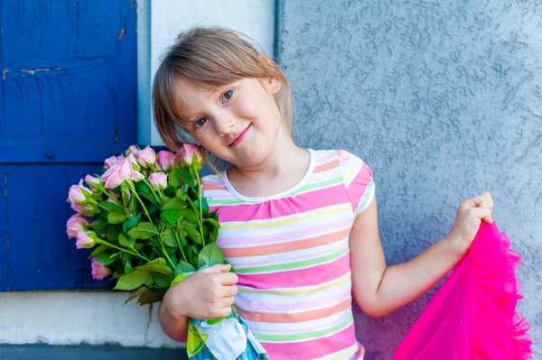 Belle petite fille aux roses roses, portrait en plein air — Photo