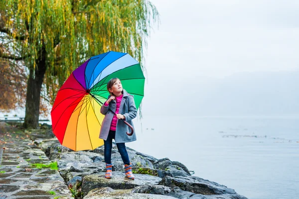 Portrait of a cute little girl with big colorful umbrella — Stock Photo, Image