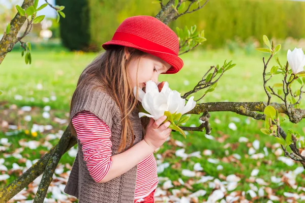 Spring portrait of a beautiful little girl in a red hat — Stock Photo, Image