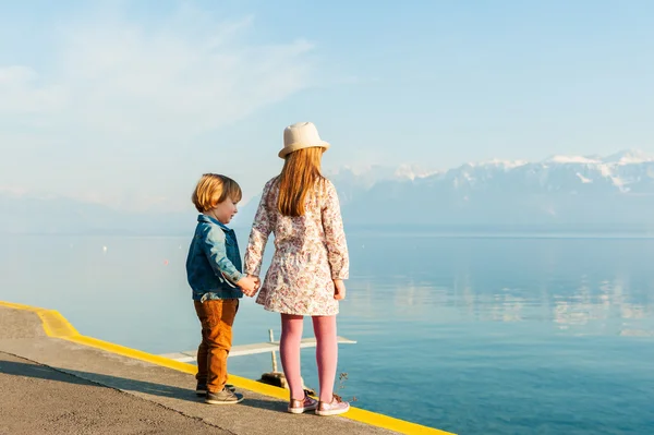 Schattige kinderen rustend naast meer op een mooie zonnige dag — Stockfoto