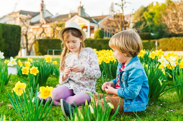 Adorable children playing with flowers on a nice sunny spring day — Stock Photo, Image