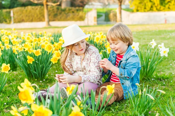 Bedårande barn leker med blommor på en fin solig vårdag — Stockfoto