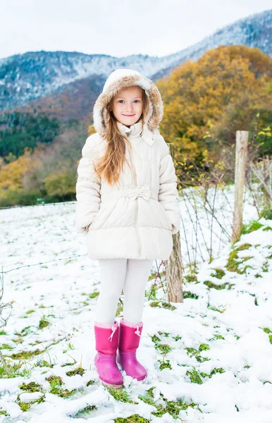 Retrato de inverno de uma menina bonita em uma jaqueta branca e botas rosa — Fotografia de Stock