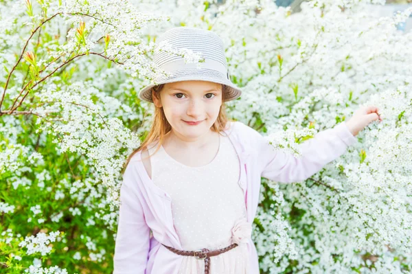 Ritratto primaverile di adorabile bambina contro bellissimi fiori bianchi — Foto Stock