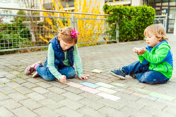 Children playing outdoors on a nice sunny day, drawing with chalk — Stock Photo, Image