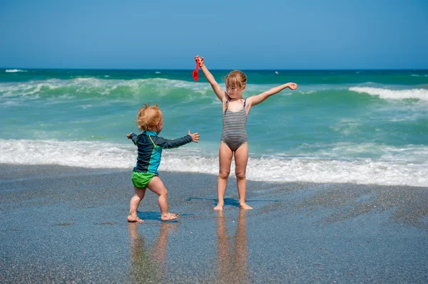 Brother and sister having fun on beach vacation — Stock Photo, Image