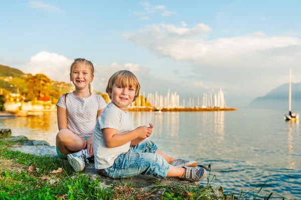 Очаровательные дети веселятся на свежем воздухе, играют на озере на прекрасном закате — стоковое фото
