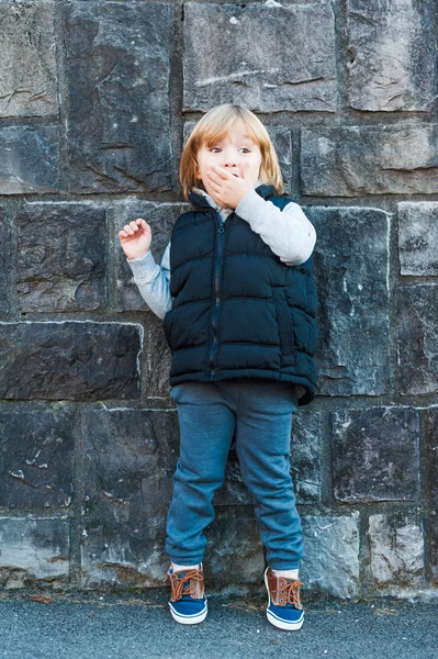 Außenporträt eines niedlichen kleinen Jungen gegen Steinmauer — Stockfoto