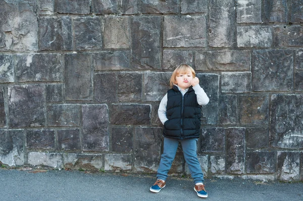 Retrato al aire libre de un niño lindo contra la pared de piedra — Foto de Stock
