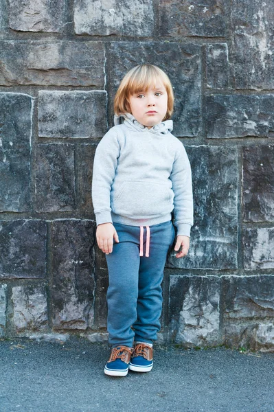 Εξωτερική πορτρέτο του ένα χαριτωμένο μικρό αγόρι πέτρινο τοίχο — Φωτογραφία Αρχείου