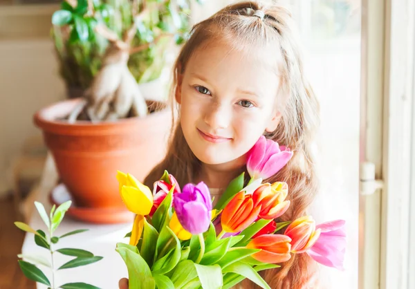 浪漫的色彩艳丽的郁金香，在室内的可爱小女孩画像 — 图库照片