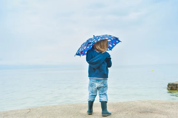Outdoor portrait of a cute toddler boy under umbrella — Stock Photo, Image