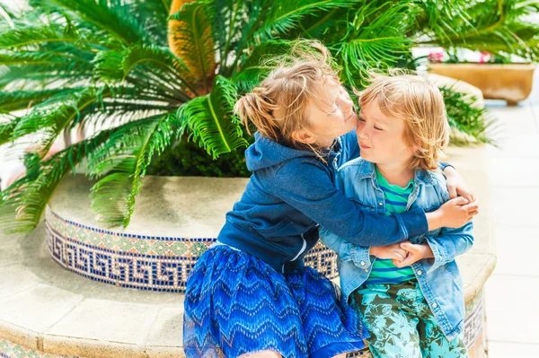 Два очаровательных ребенка в отпуске, старшая сестра обнимает своего младшего брата — стоковое фото