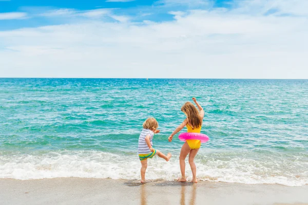 Two kids having fun on summer vacation, playing in the sea — Stock Photo, Image