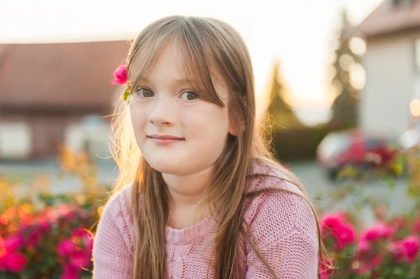 Portret van een schattig klein meisje rusten buitenshuis op een mooie zonnige avond close-up — Stockfoto