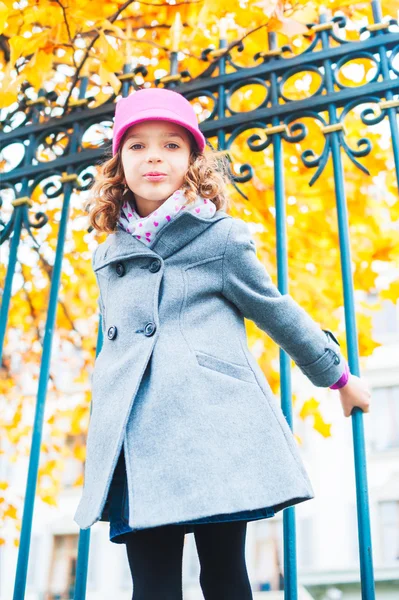 Outdoor portrait of a cute little girl, wearing grey coat and pink hat — Stock Photo, Image