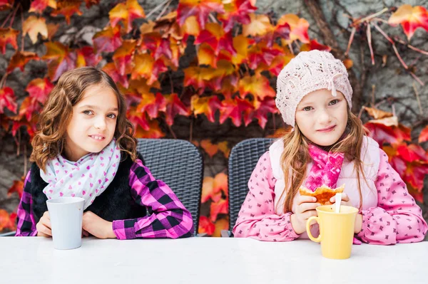 Adorables petites filles qui boivent du chocolat chaud sur une terrasse — Photo